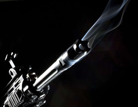 assault rifle that has smoke coming out of its barrelの写真素材