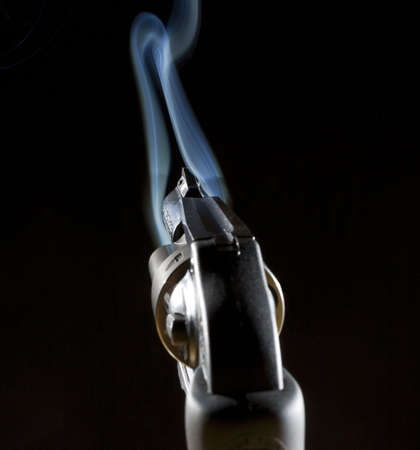 handgun that has an o ring of blue smoke near the barrelの写真素材