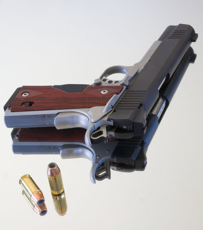 Semi automatic pistol and bullets that are on a mirrorの写真素材