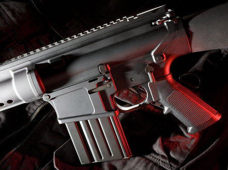Assault rifle on a tactical vest with red gels from the right