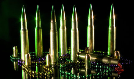 Fifty caliber cartridges with Mardi Gras beads and one is spewing red stuff