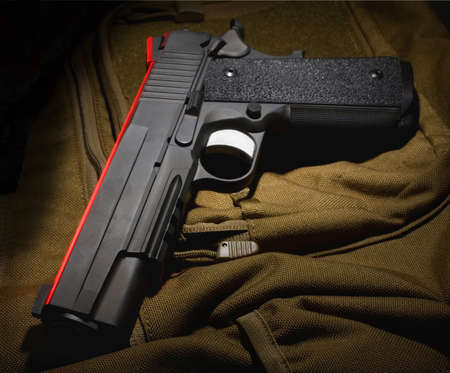 Semi automatic pistol that is on a nylon computer bagの写真素材