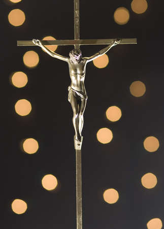 Bronze crucifix with bright yellow lights sparkling behindの写真素材