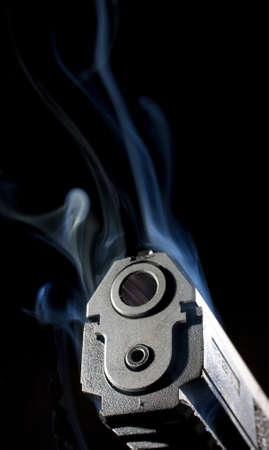 Semi automatic pistol that has smoke near itの写真素材