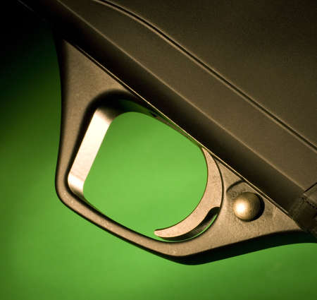 Trigger on a shotgun that is on a green backgroundの写真素材
