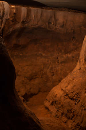 Very little light on a trail winding through a caveの写真素材