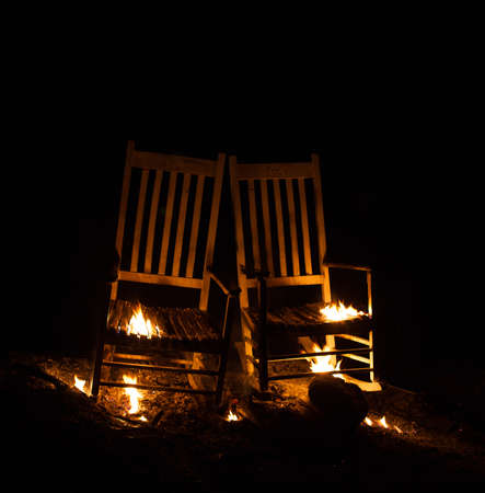 Pair of rocking chairs that are barely burningの写真素材