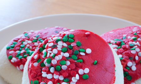 Bright cookies that have red frosting and green sprinklesの写真素材