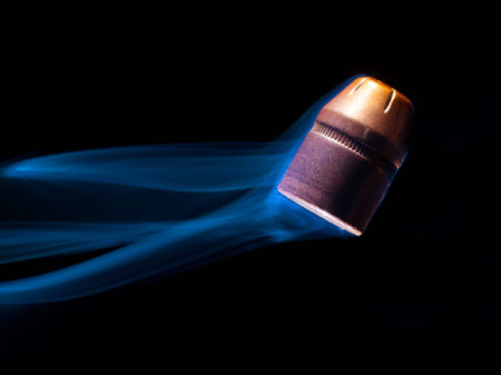 Handgun bullet that is turning up straight with smoke behind