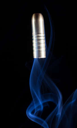 Copper bullet launched skyward with lots of smoke underneathの写真素材