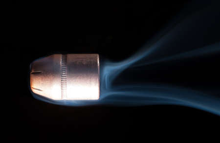 Hollow point handgun bullet with smoke trailing behindの写真素材