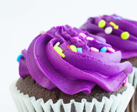 Thick and sweet purple frosting on cupcakesの写真素材