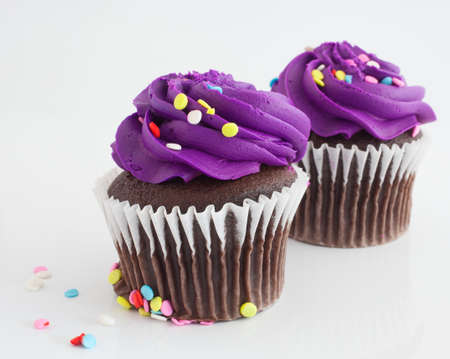 Purple frosted chocolate cupcakes on a white backgroundの写真素材