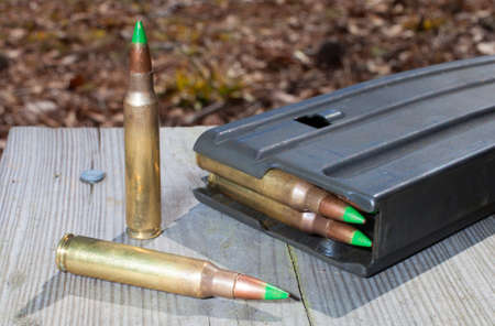 Magazine on wood planks with green tipped metal ammoの写真素材