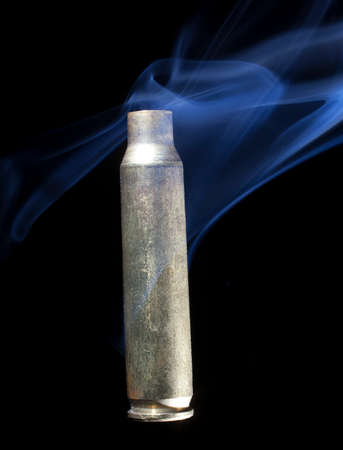 Brass casing from ammunition that has been fired and is smokingの写真素材