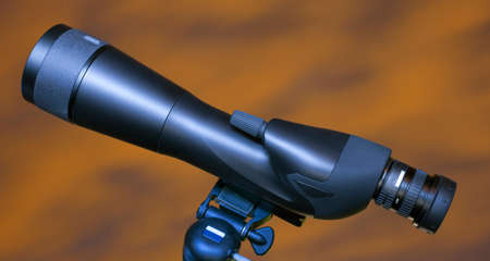 High powered spotting scope with an orange and yellow sky behindの写真素材