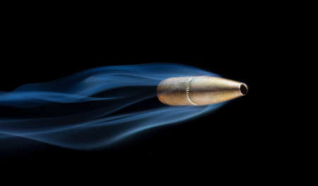 Bullet with copper plating with smoke behind that looks like it is flyingの写真素材