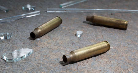 Three rifle casings with glass that are on concreteの写真素材