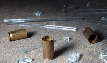 Empty handgun shells on concrete with broken glass aroundの写真素材