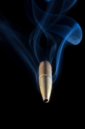 Bullet with a copper coating and smoke coming at the viewerの写真素材