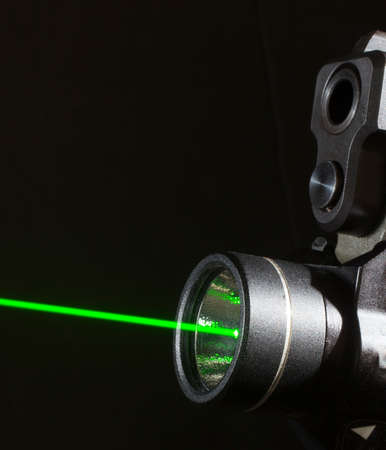 Green laser on at the bottom of a handgunの写真素材
