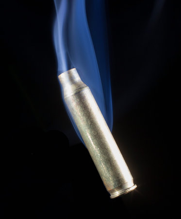 Empty shell smoking after it has been ejected from the gun