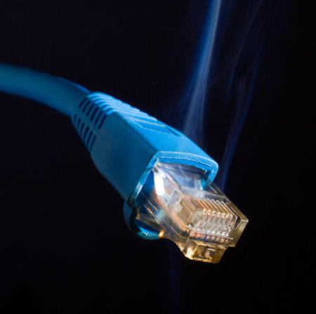 Blue lan connection for a computer with smoke rising on black