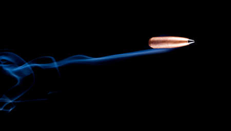 Polymer tipped bullet with copper plating and smoke behindの写真素材