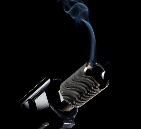 Smoking barrel of a gun with a dark background