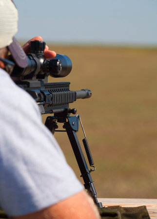 Shooter behind an AR-15 changing elevation for a long shot