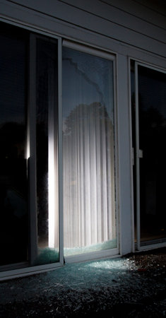 Shattered sliding glass door after a burglar broke in