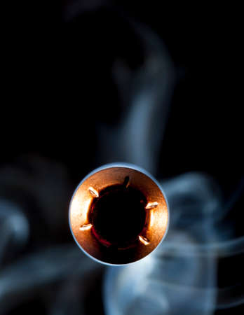 Copper jacketed bullet with a hollow point and smoke behindの写真素材