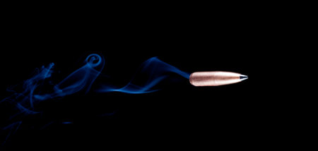 Smoke behind a copper plated bullet with a black polymer tip