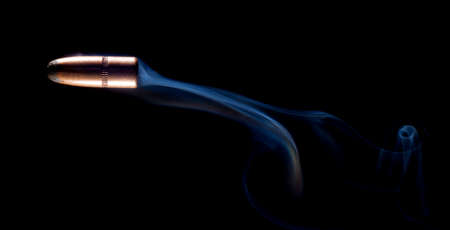 Lead tipped and copper plated bullet with smoke on blackの写真素材
