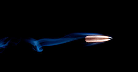 Copper plated lead bullet with a polymer tip and smoke behindの写真素材