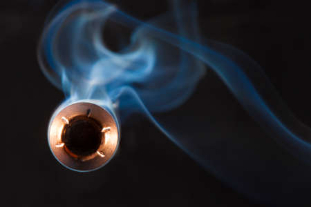 Copper plated bullet with a hollow point design and smoke behindの写真素材