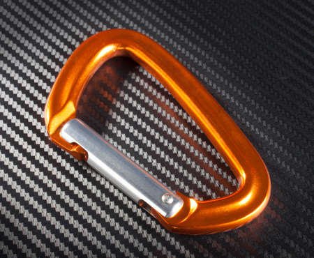 Orange caribiner that does not lock on a graphite backgroundの写真素材