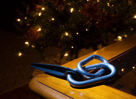 Carabiners and a piton on a table with Christmas tree behind