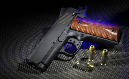 Handgun with ammunition on a rubber mat and blue highlights