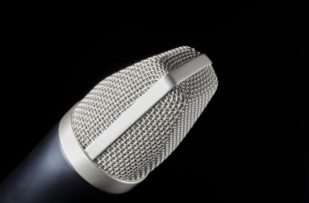 Microphone in silver mesh that is on a dark background の写真素材