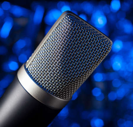 Metal covered microphone that has a blue backgroundの写真素材