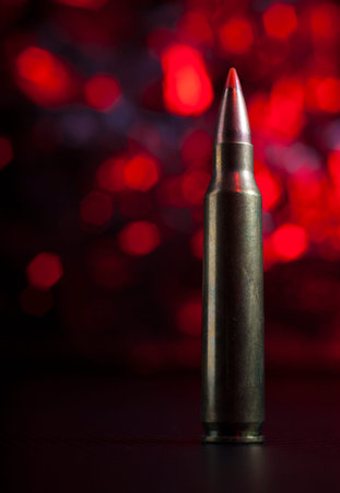 Bullet and cartridge used in an AR-15 with a red backgroundの写真素材