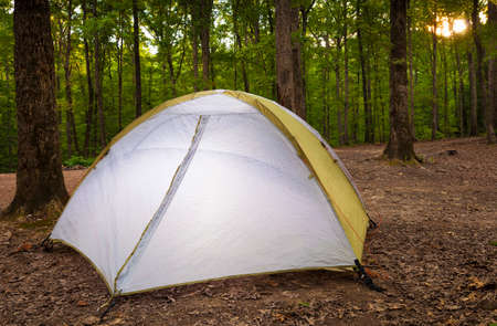 Sun about to set over a campsite with a nylon tentの写真素材