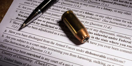 Cartridge and pen with dishonorable discharge question on FBI background checkの写真素材