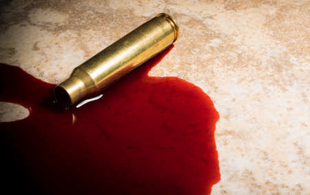 Blood and an empty rifle casing on the floorの写真素材