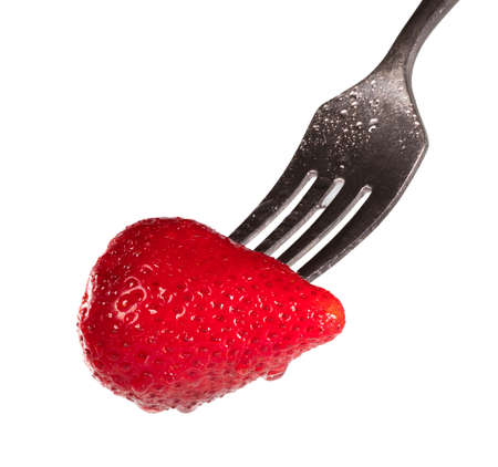 Strawberry dripping with moisture on a fork isolated on whiteの写真素材