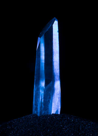 Quartz crystal on a black background with blue lightの写真素材