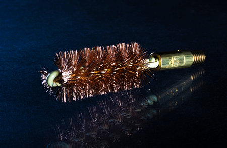 Gun cleaning brush for a .45 bore handgun on a dark background