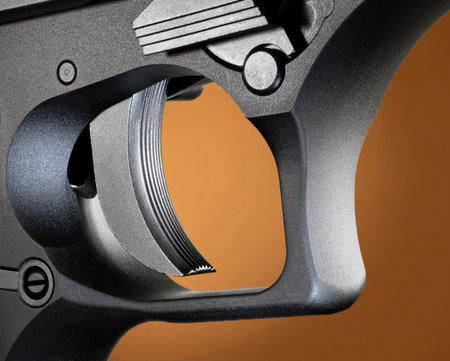 Trigger on a semi auto pistol on a beige background