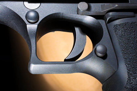 Semi automatic pistol trigger with a brown and black background
